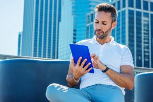 AANWP Urban Practice - Board Certified Digital Client Management in Metropolitan Wellness Setting AANWP board certified practitioner using tablet for client management on modern urban rooftop with city skyline background